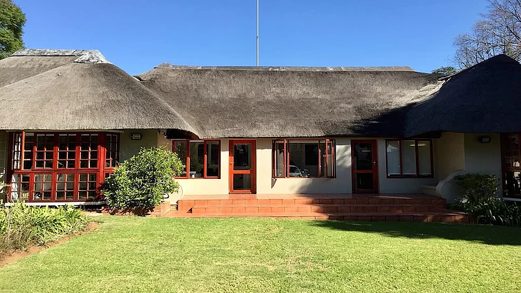 This lodge-style building features a distinctive thatched roof and an adjoining, well-tended lawn. It shows the Friedrich Ebert Foundation’s office in Johannesburg.