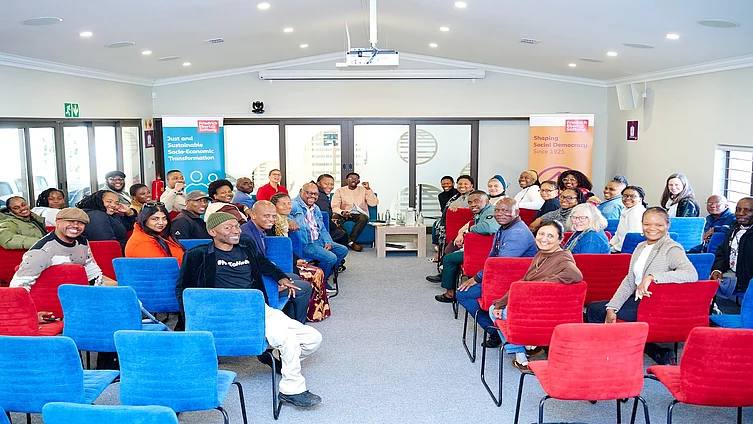 A group of participants seated in a conference room during a Friedrich-Ebert-Stiftung South Africa event, with participants facing one another in an open, discussion-style seating arrangement.